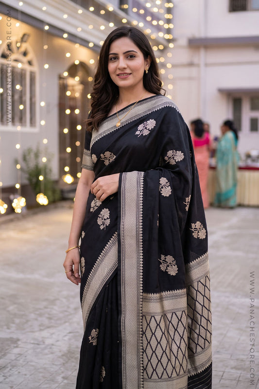 Black Banarasi silk saree worn by a Indian beautiful women. Outdoor courtyard decorated with warm string lights.