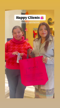Two happy women standing indoors holding a large shopping bag with the word 'Panache' visible on it. Happy client title