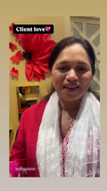 A woman wearing a bright pink top and a white embroidered scarf, smiling in an indoor setting with a decorative red flower on the wall behind her. A text overlay reads 'Client love 💕'.