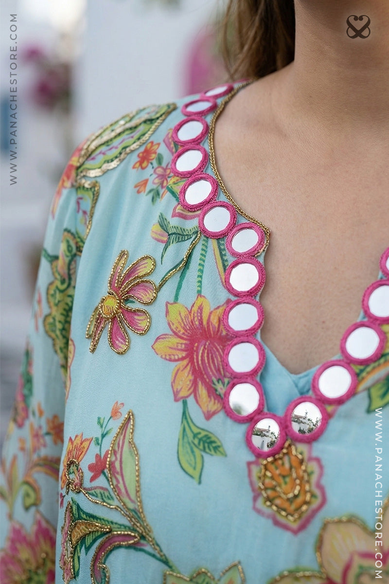 Close-up of a floral dress with a decorative neckline featuring white buttons.