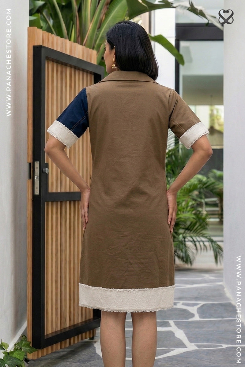 Woman wearing a brown dress with white trim in an outdoor setting