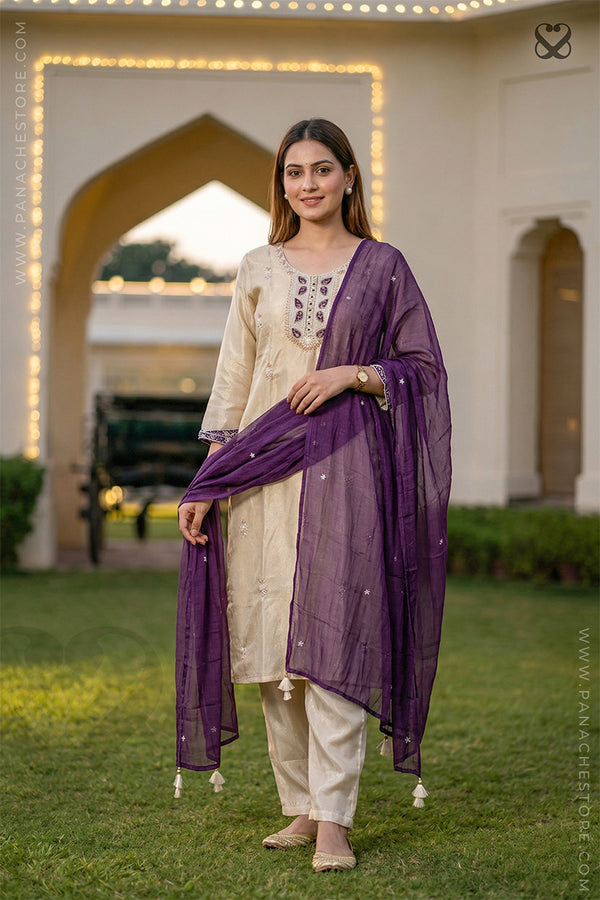 Woman in cream white slawar suit set with purple dupatta standing on grass