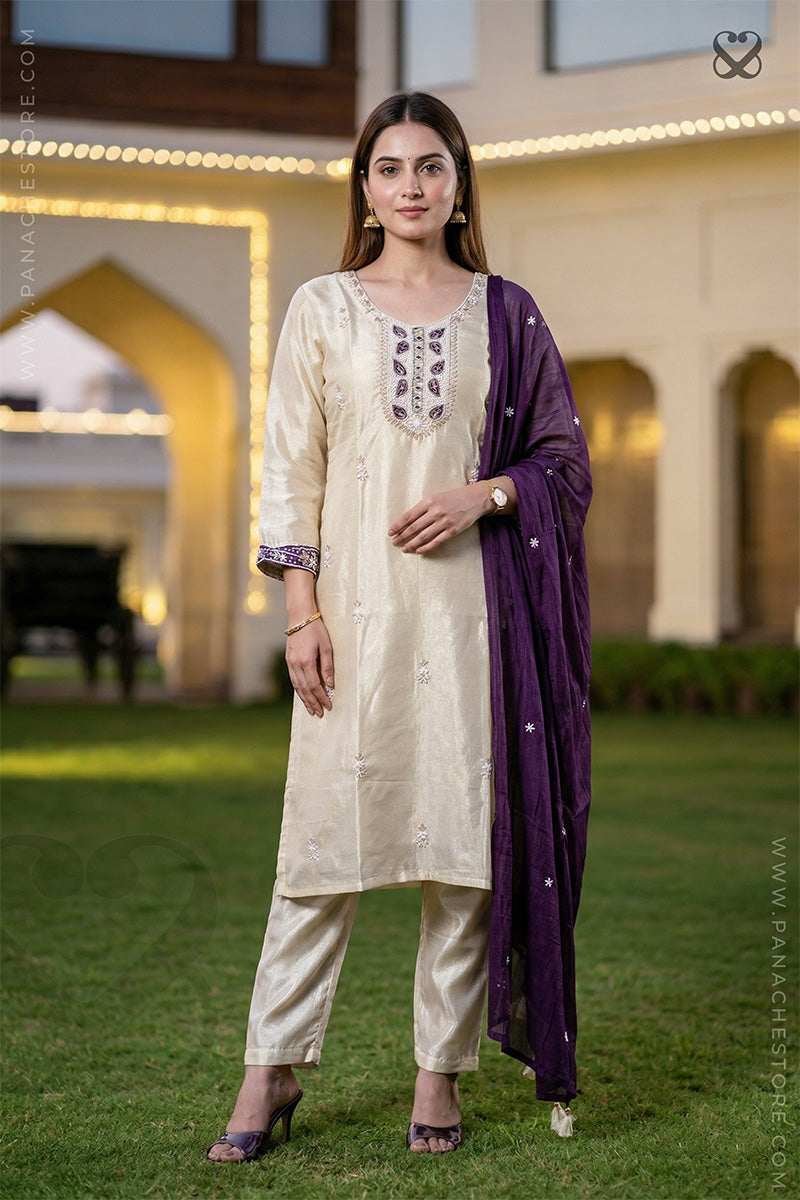 Woman in cream white slawar suit set with purple dupatta standing on grass