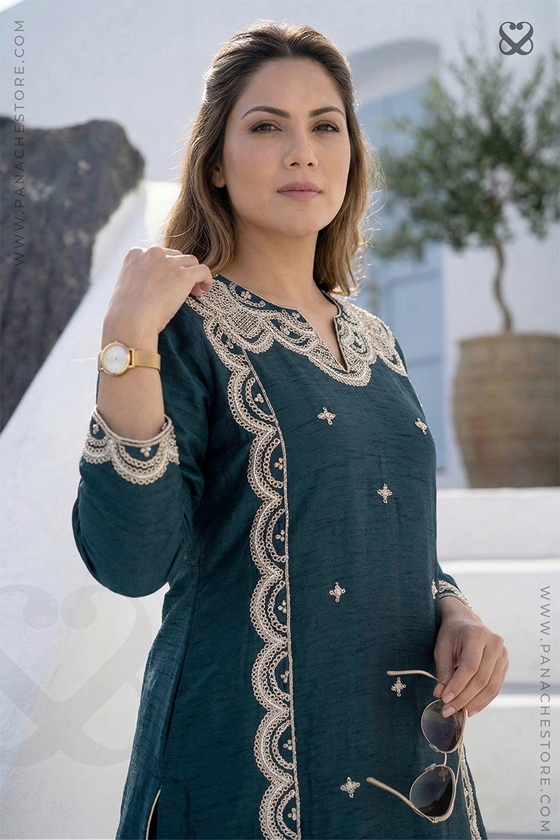 Woman in deep teal green embroidered kurti standing on steps