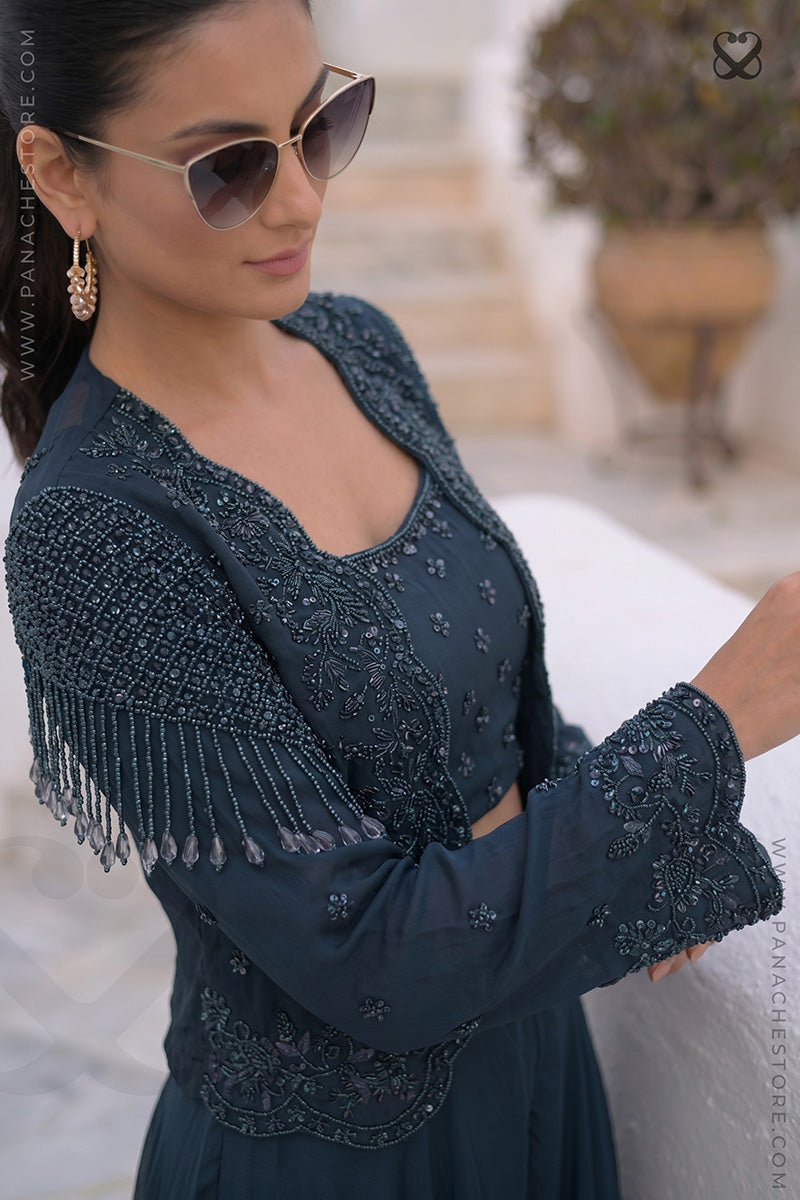 Woman wearing a designer deep peacock teal heavy embellished top with matching skirt