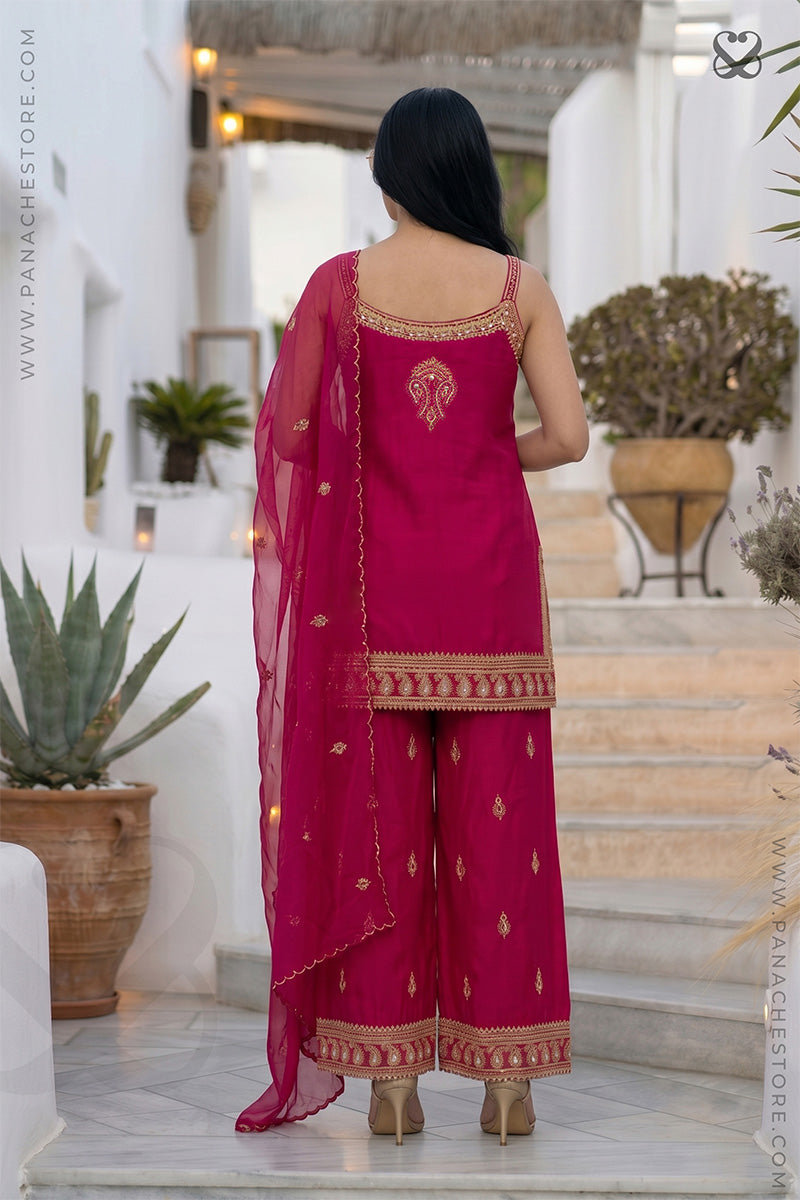 Woman in a pink traditional sleeveless kurti top and plazo pants all with gold embroidery embellishments