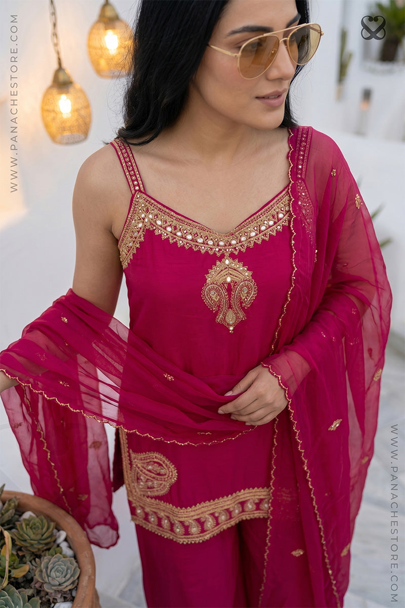 Woman wearing a pink traditional sleeveless kurti top with gold embroidery and plazo pants