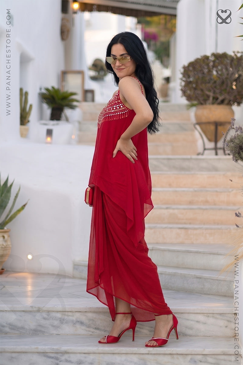 Woman in a red party wear dress standing on steps with a blurred background