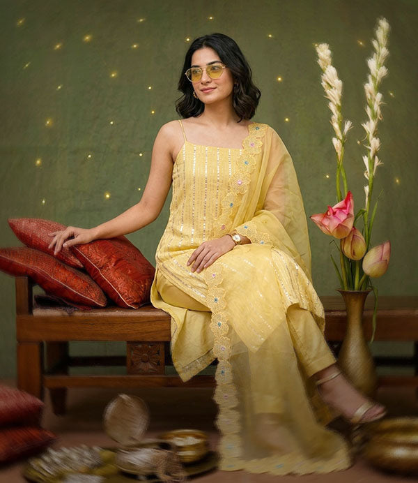 An Indian female in yellow designer suit making a Haldi ceremony look outfit shot.