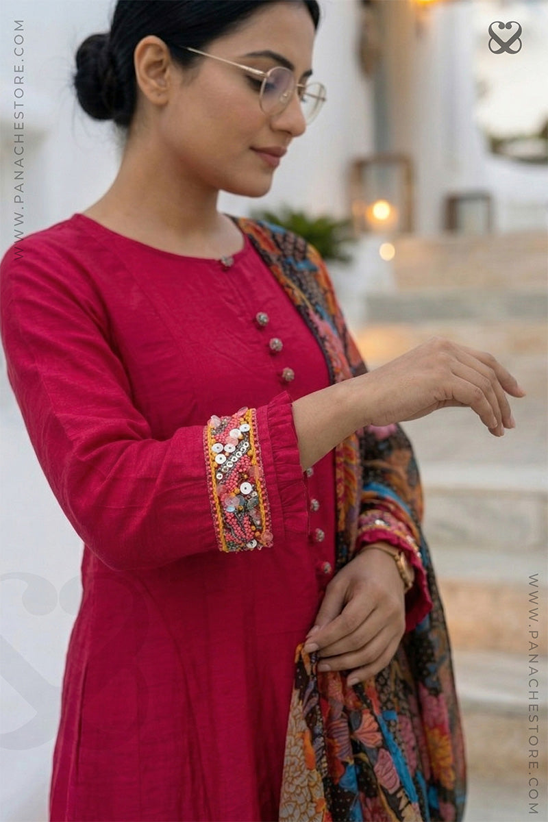 Woman in a red-pink kurti outfit with sequin embellishments and floral print dupatta