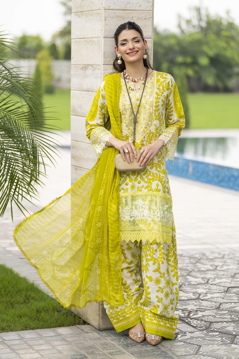 Woman in a yellow and white traditional outfit standing by a poolside.