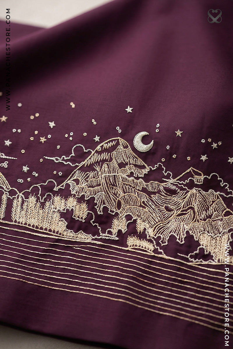 Embroidered design of mountains and stars on a maroon fabric.