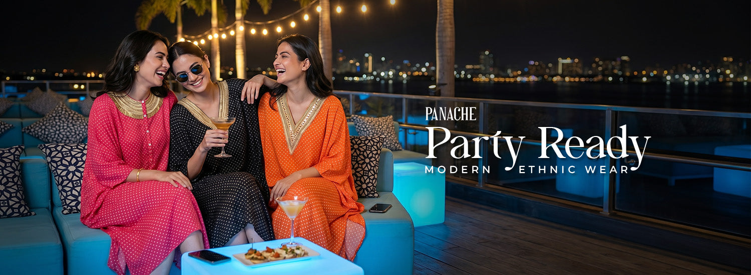Three women in colorful outfits sitting on a rooftop at night with city lights in the background, promoting Panache Party Ready modern ethnic wear.