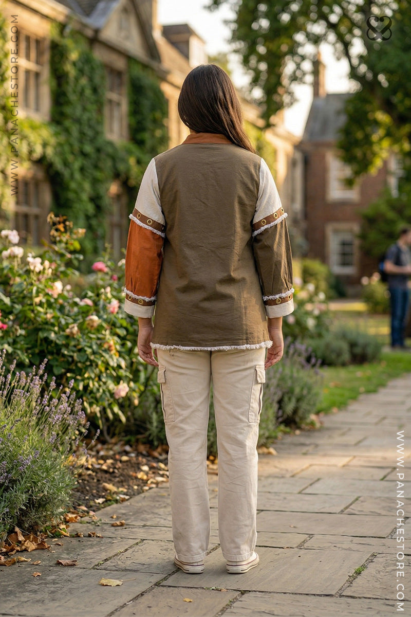 Person wearing a green and white outfit walking along a garden path with buildings and greenery in the background.