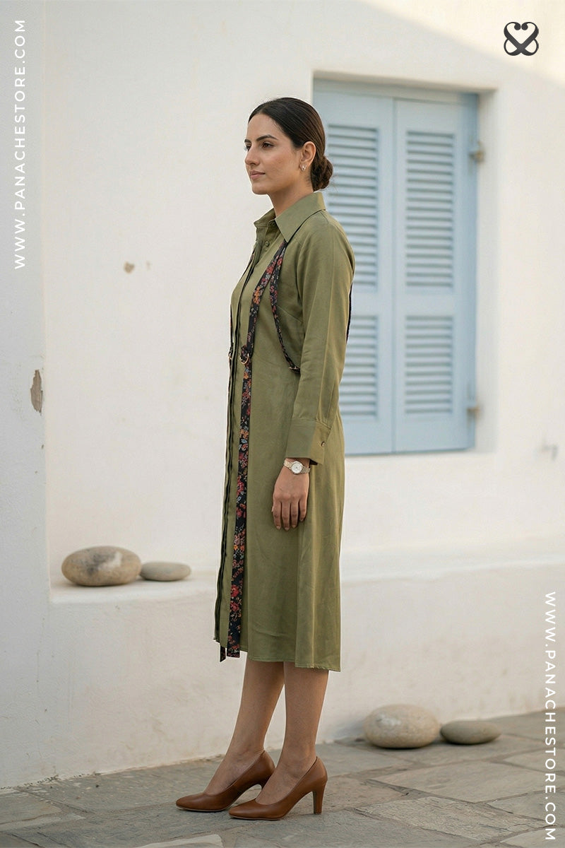 Woman wearing a green dress with a patterned scarf in an outdoor setting.