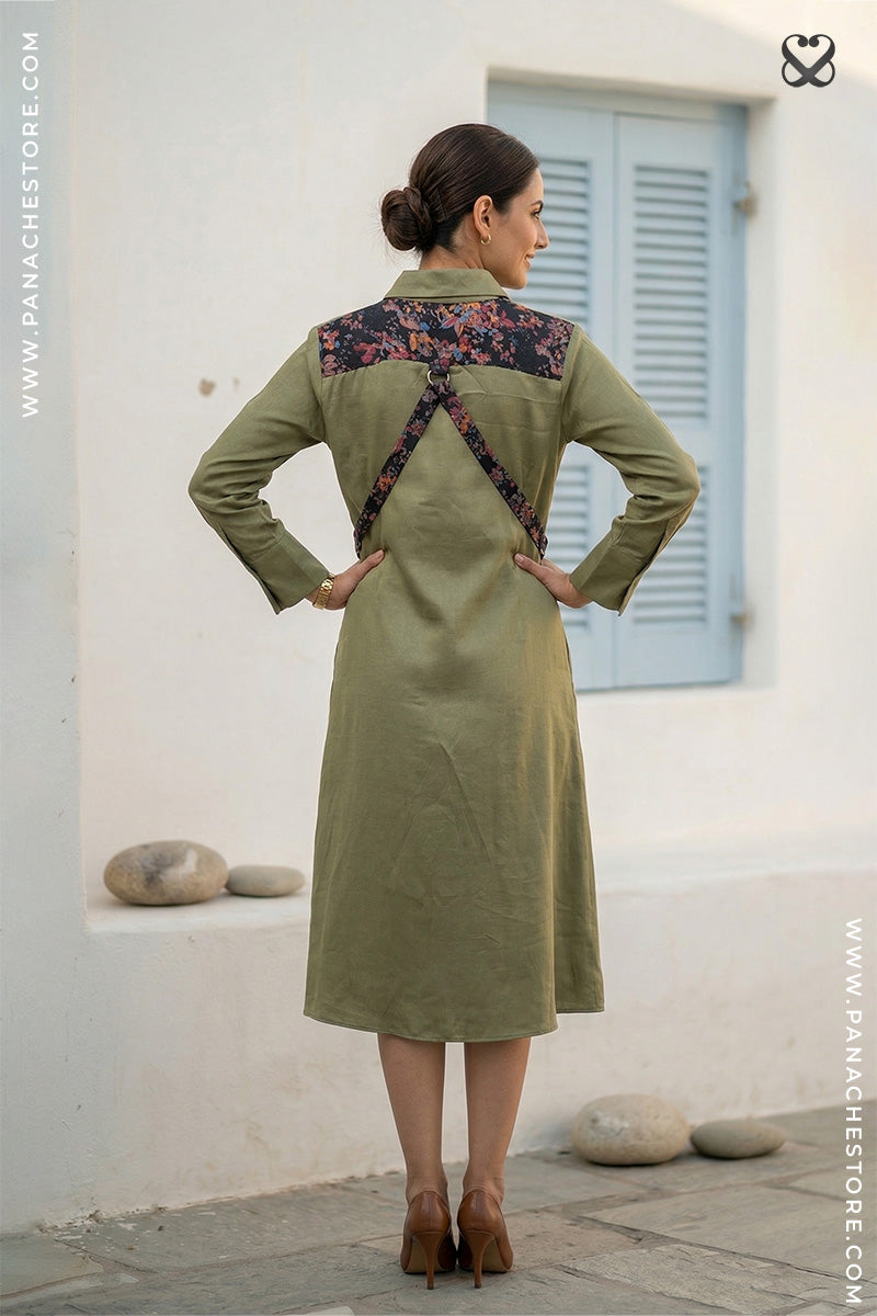 Woman wearing a green dress with floral details in a white outdoor setting