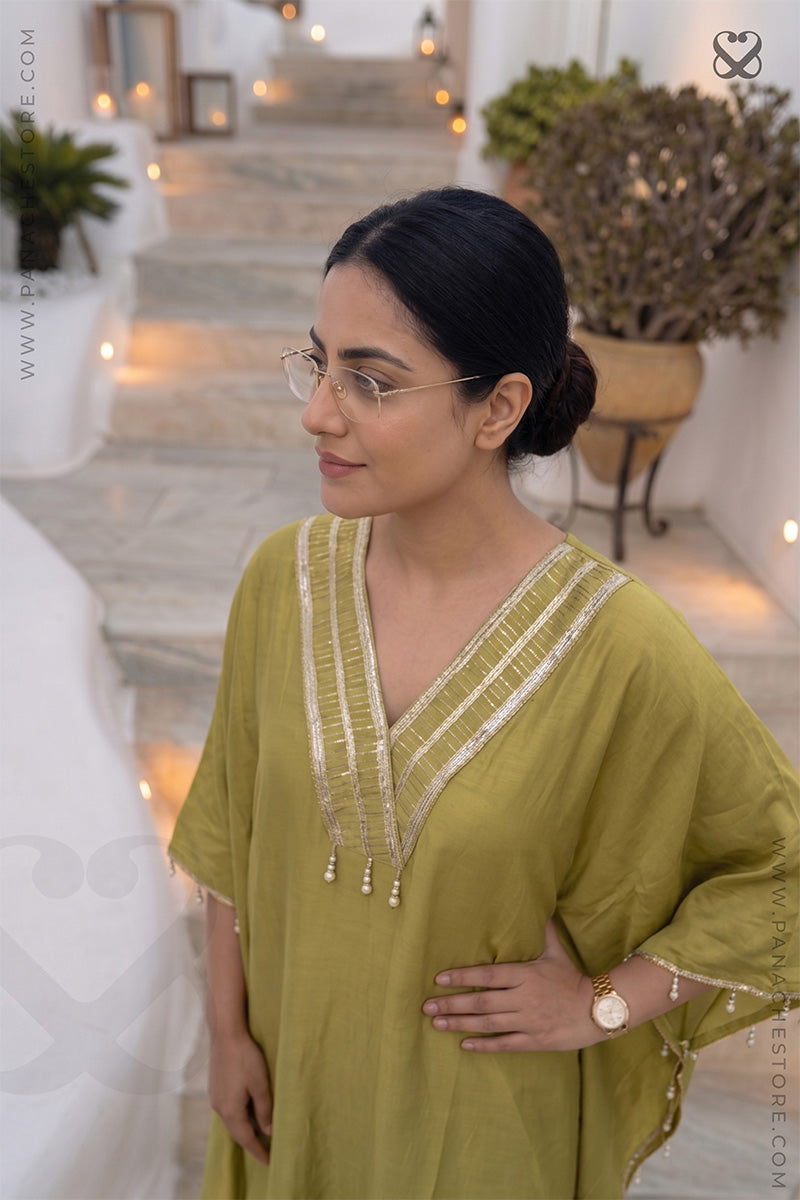 Woman in an olive green Kaftan with zari strips neckline