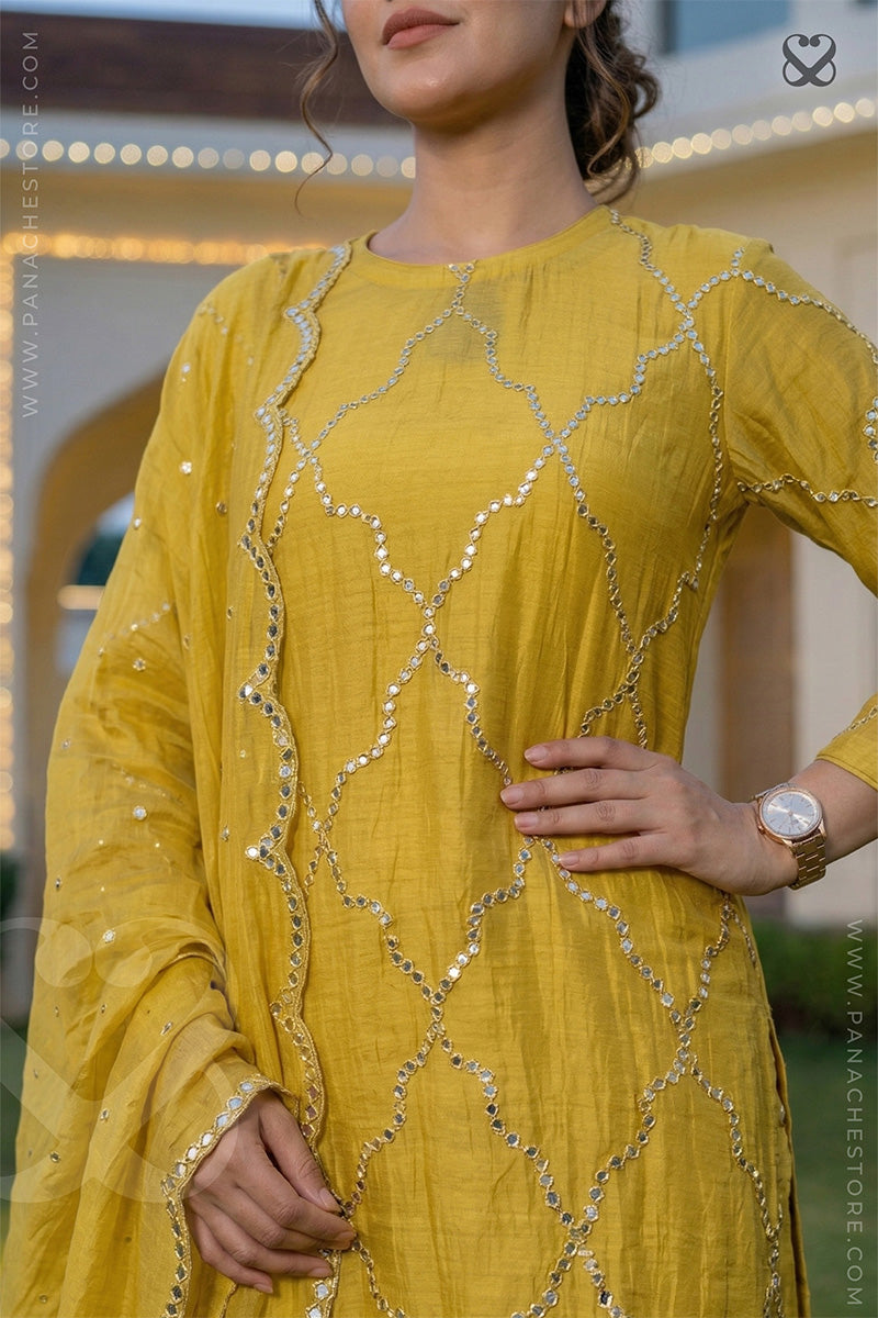 Woman in a yellow designer suit set with mirror work and matching dupatta