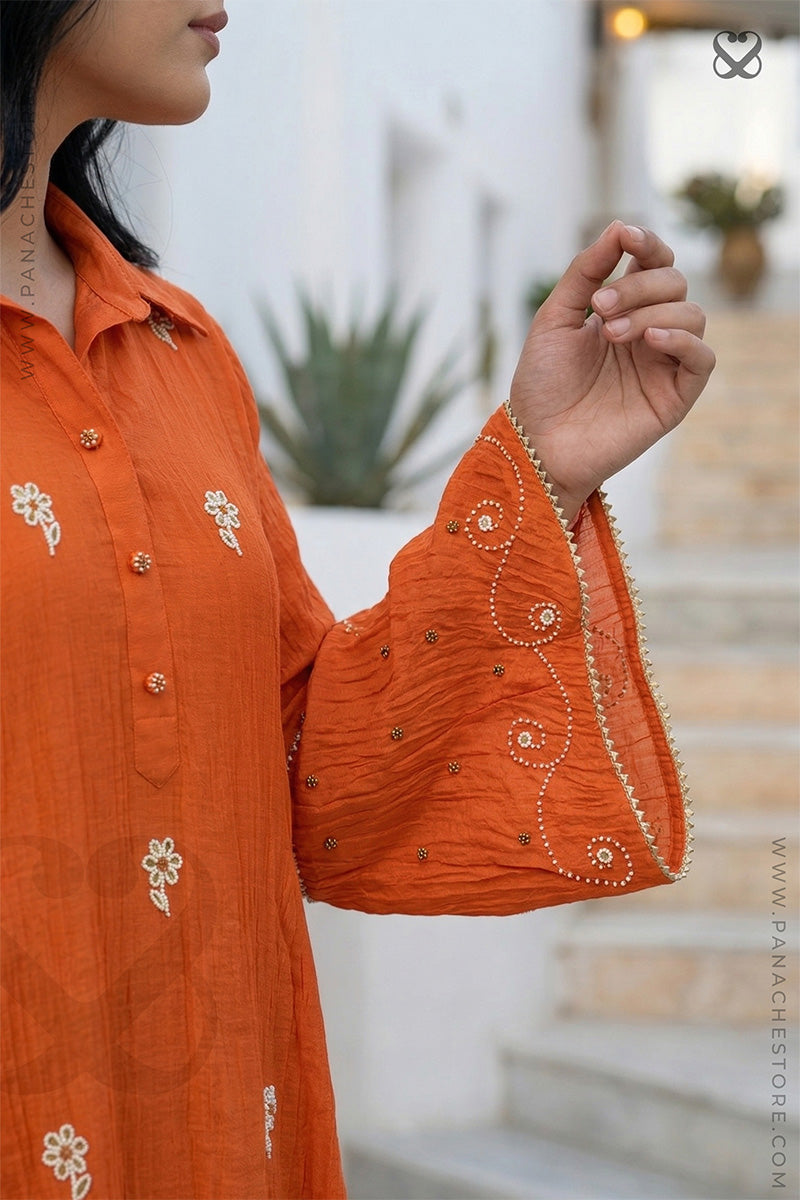 Orange embroidered kurta worn by a woman with a blurred background