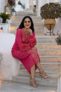 Woman in a pink designer party wear dress with ruffled floral sleeves sitting on steps