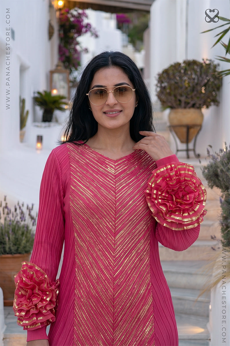 Woman in a pink designer party wear dress with ruffled floral sleeves