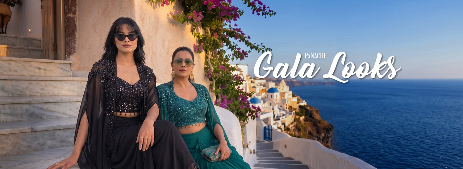 Two women in designer Cap outfit set attire sitting on a steps with a scenic ocean view and 'Gala Looks' branding.
