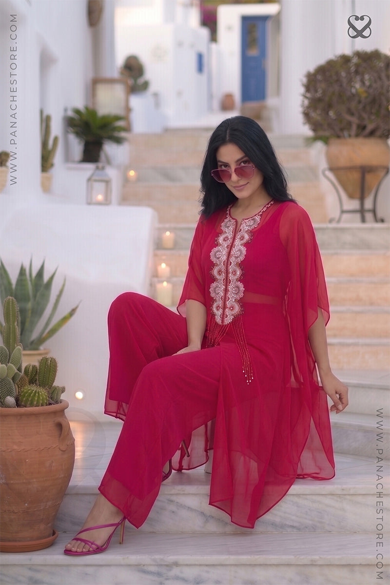Woman in a red-pink kaftan outfit sitting on steps