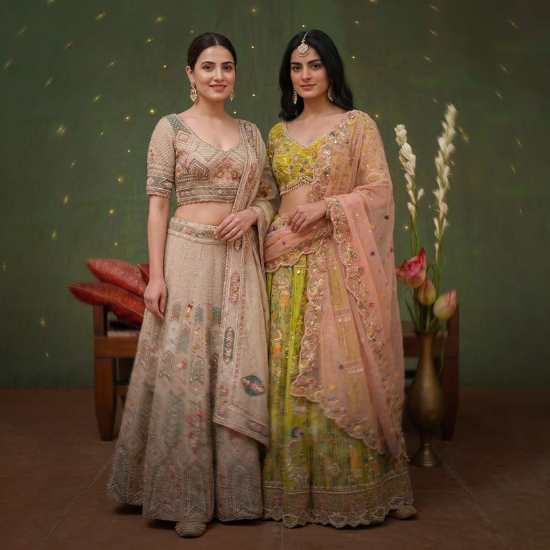 Two Indian females in Designr bridal lehenga look in wedding environment 