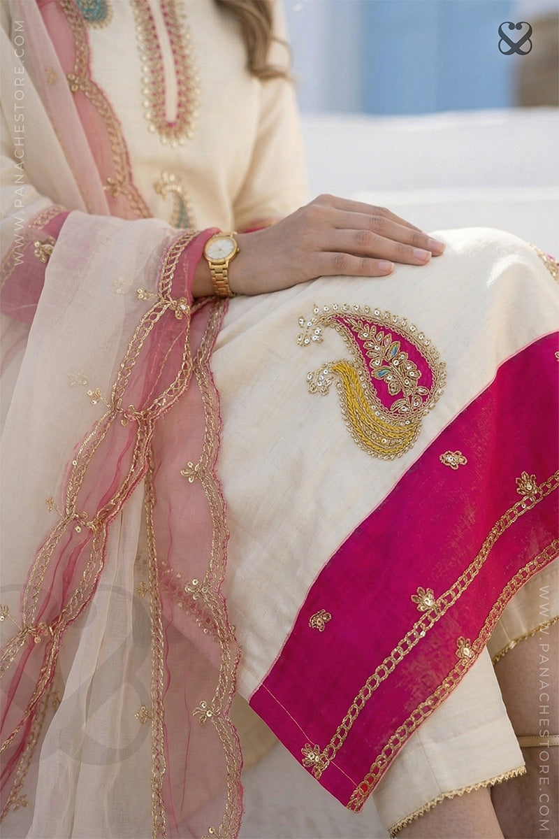 Close-up of a traditional embroidered fabric with pink and gold details.