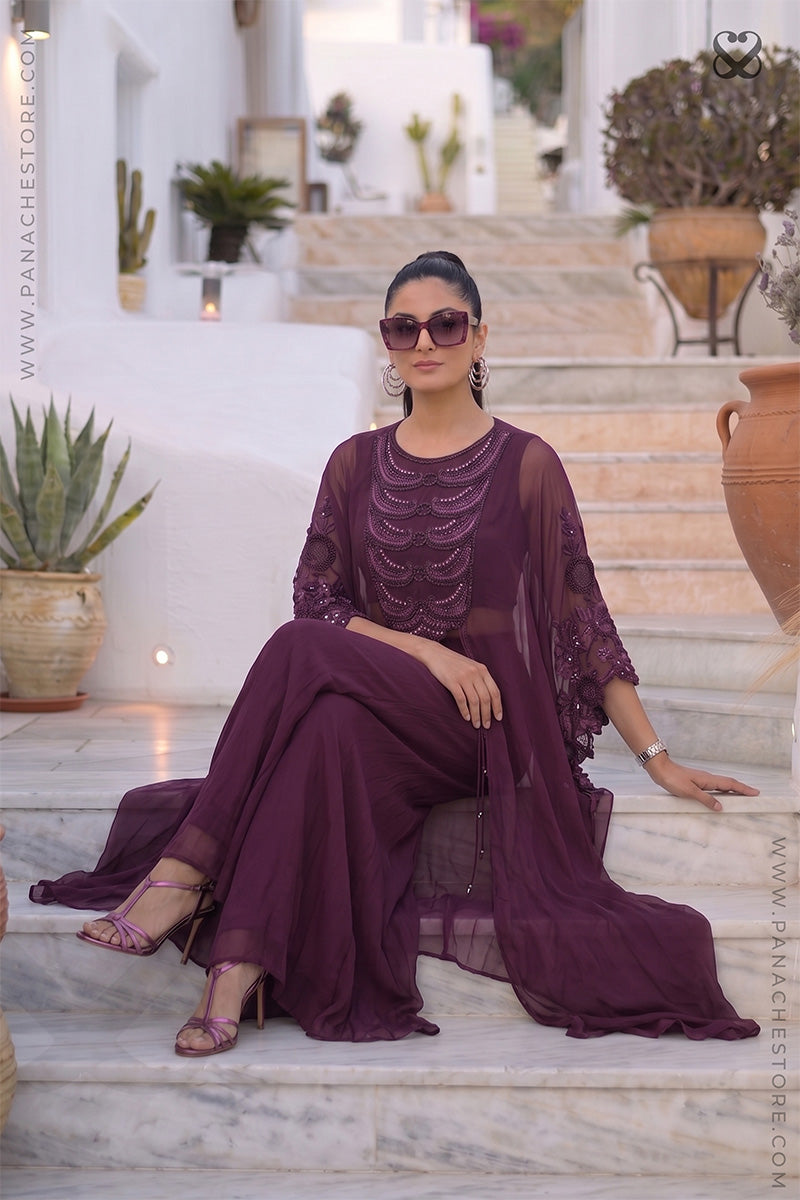 Woman in a wine-purple kaftan outfit set sitting on steps