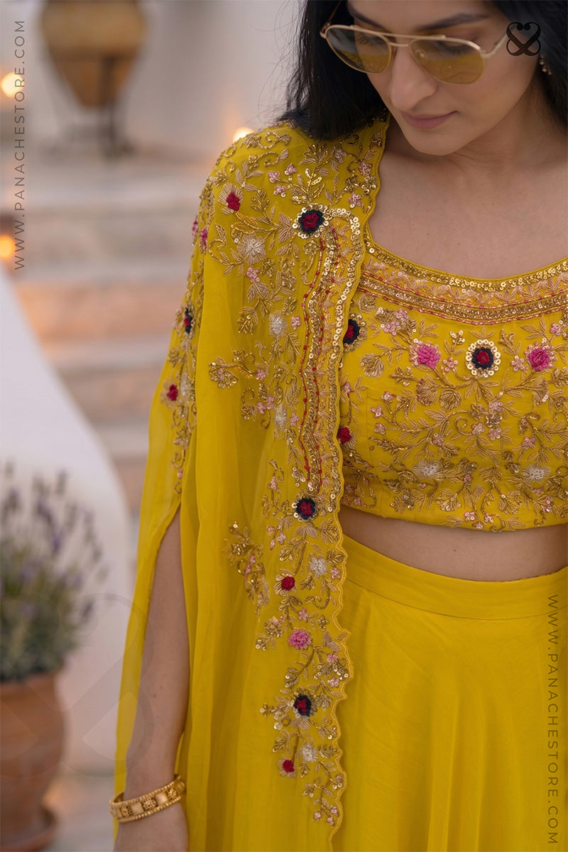 Woman wearing a designer yellow embroidered outfit with zardozi and meenakari work in an outdoor setting
