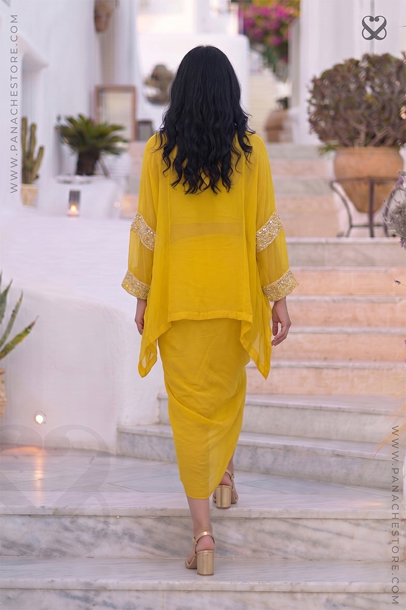 Woman wearing a yellow kaftan outfit with white embroidery climbing on step